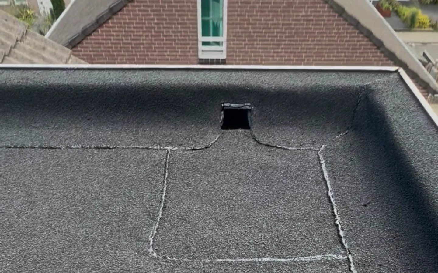 Afgewerkt bitumen plat dak met zichtbare dakafvoer