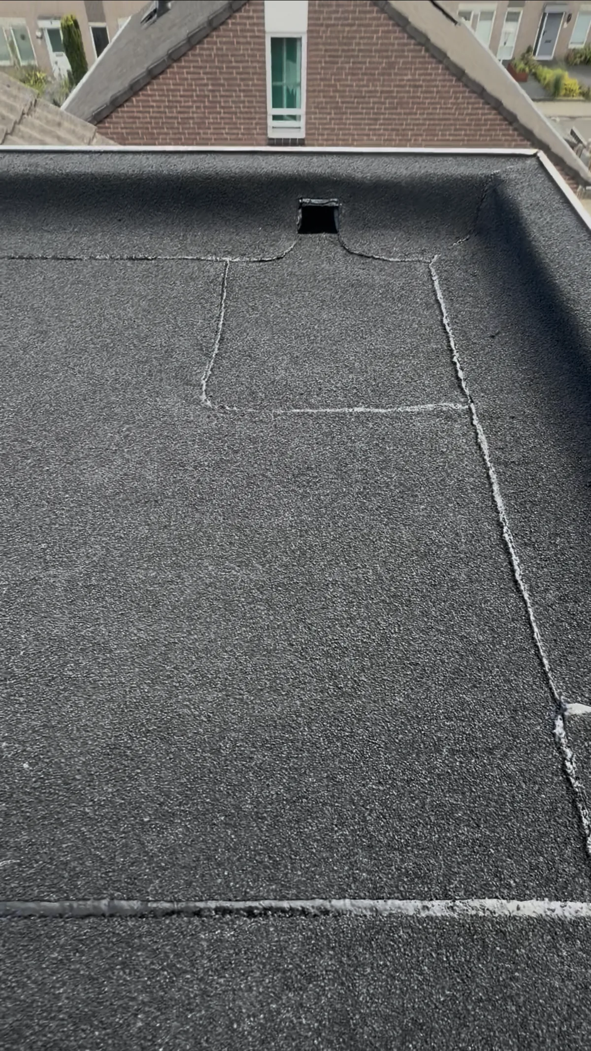 Detailbeeld van de bitumen dakbedekking en dakafvoer van het project in Heerlen